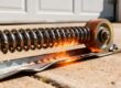 Texas heat damaging garage door components: spring, rollers, track.